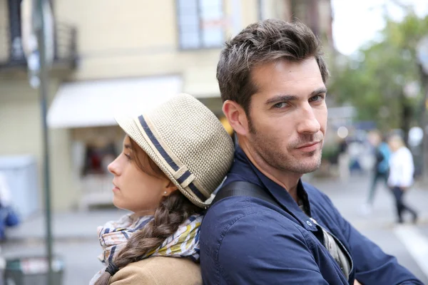 Couple in street leaning back to back — Stock Photo, Image