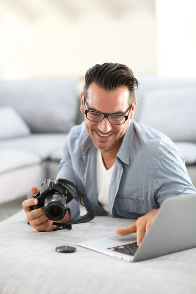 Homem usando câmera digital e laptop — Fotografia de Stock