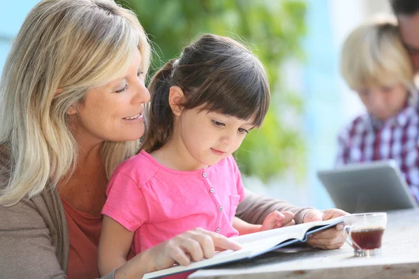 Femme avec fille apprenant à lire — Photo