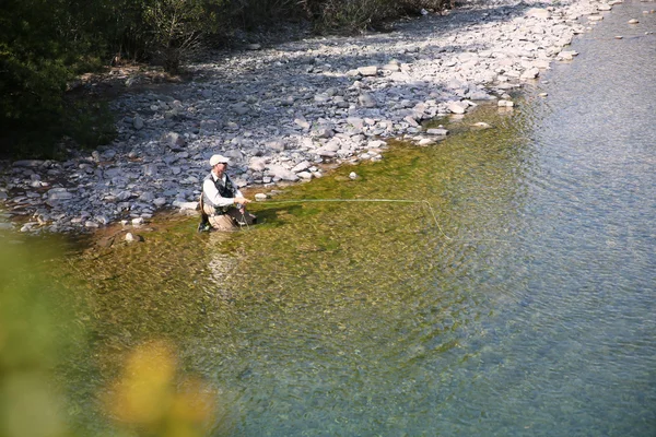 Pêcheur pêche à la mouche dans la rivière — Photo