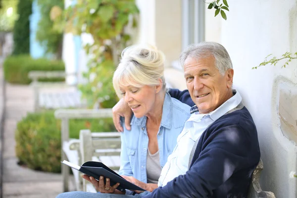 Senior couple reading book outside — Stock Photo, Image