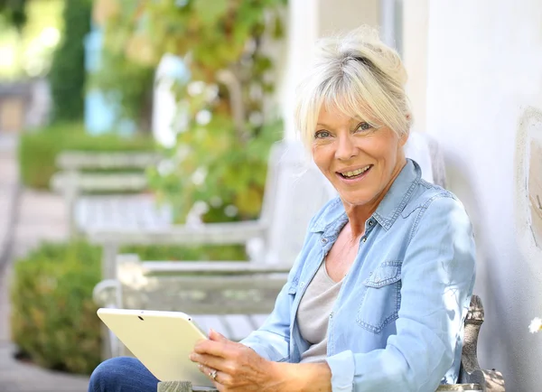 Frau entspannt sich draußen und nutzt Tablette — Stockfoto