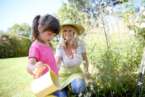 Vrouw met meisje planten water geven — Stockfoto