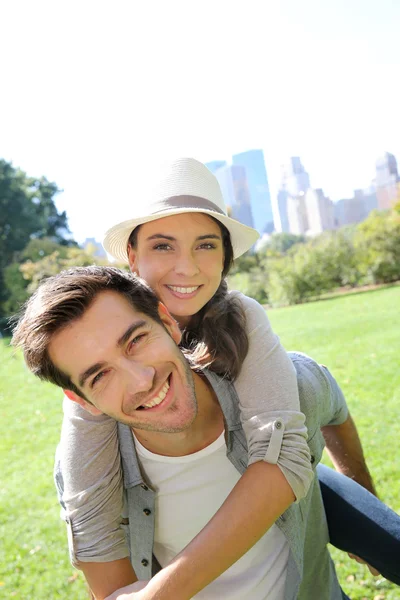 Man die geeft piggyback rit te vriendin — Stockfoto