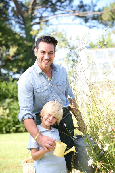 Pai e filho regando plantas — Fotografia de Stock