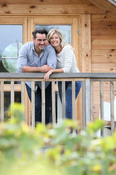 Pareja de pie en la terraza cabaña de madera — Foto de Stock