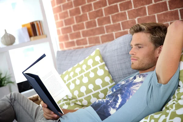 Muž v bytě čtení knihy — Stock fotografie