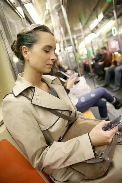 Businesswoman in subway reading message — Stock Photo, Image