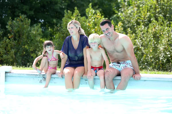 Family of four enjoying swimming time — Stock Photo, Image