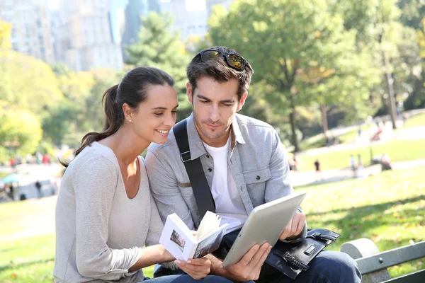 Tourists looking at traveler's guide — Stock Photo, Image