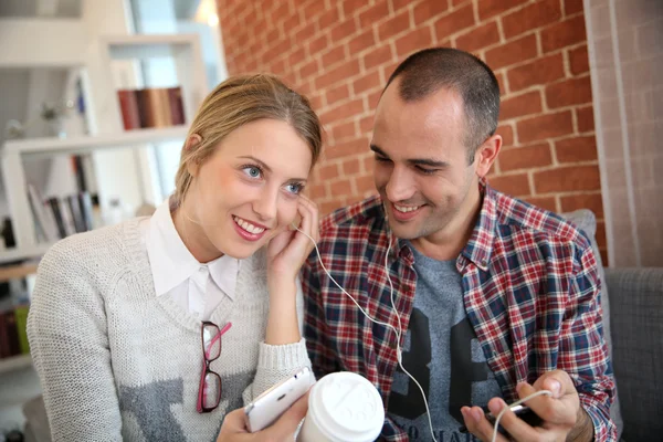 Friends listening to music on smartphone — Stock Photo, Image