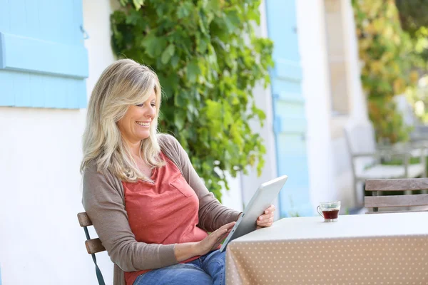 Жінка сидить на терасі і використовує планшет — стокове фото