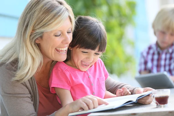 Mujer con hija enseñando a leer —  Fotos de Stock