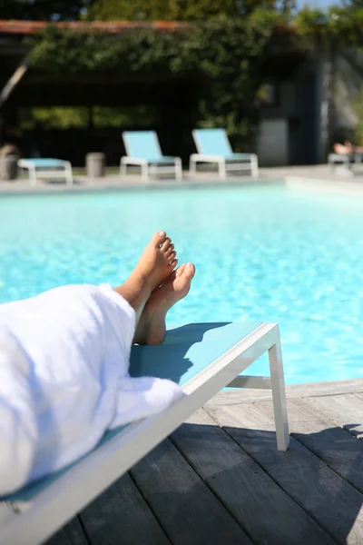 Pés de mulher relaxando em cadeira longa — Fotografia de Stock