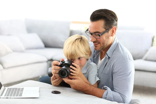 Uomo con ragazzo giocare con fotocamera reflex — Foto Stock