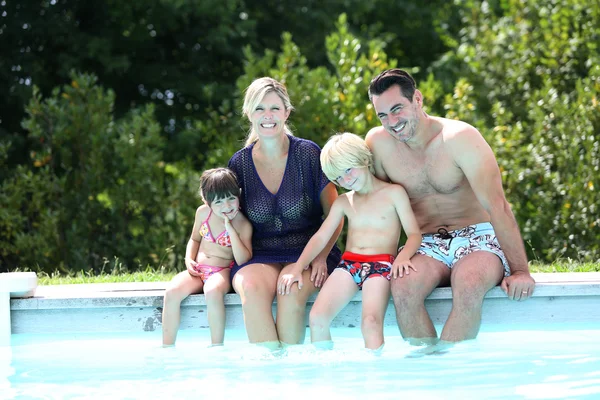 Family of four enjoying swimming time — Stock Photo, Image