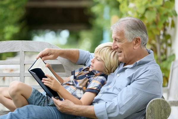 Grandfather reading book with grandson — Stock Photo, Image