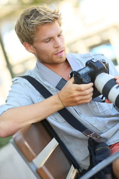 Fotógrafo com câmera no banco — Fotografia de Stock