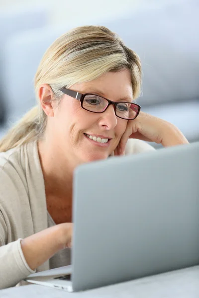 与眼镜 websurfing 笔记本电脑上的女人 — 图库照片