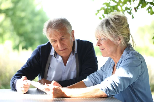 Couple aîné utilisant une tablette numérique — Photo