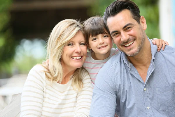 Eltern mit Tochter sitzen draußen — Stockfoto