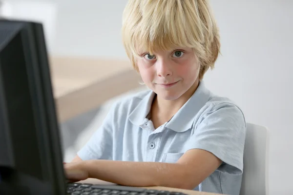 Bilgisayar başında oturan okullu çocuk — Stok fotoğraf