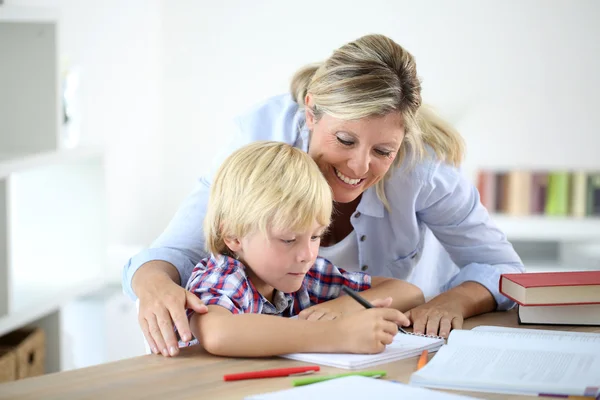 Mãe ajudando menino para fazer lição de casa — Fotografia de Stock