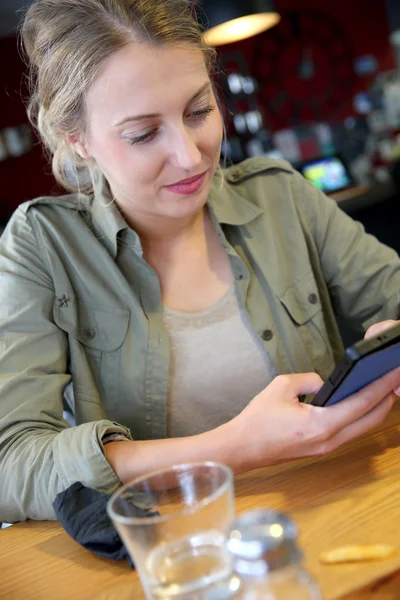 Menina estudante no lounge usando smartphone — Fotografia de Stock