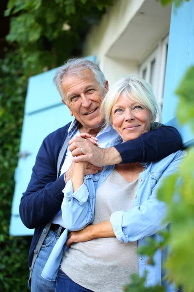 Man omfamnar sin hustru på house — Stockfoto