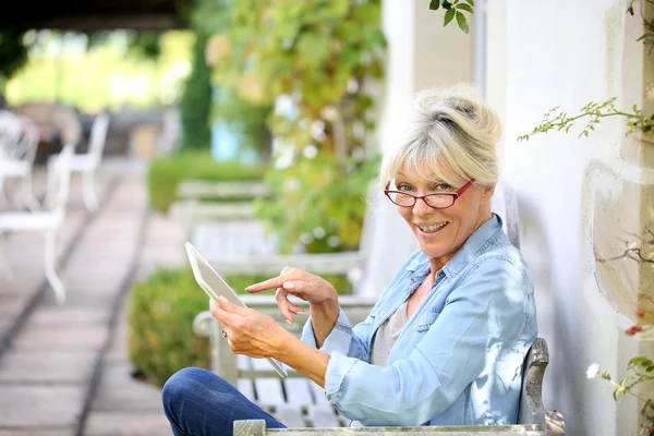 Mujer relajante al aire libre y el uso de tabletas —  Fotos de Stock