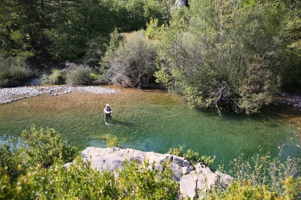 Pêcheur pêche à la mouche dans la rivière — Photo