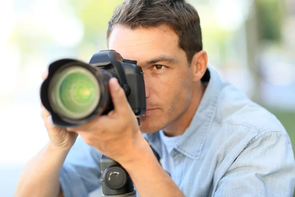 Fotógrafo usando câmera reflexa fora — Fotografia de Stock