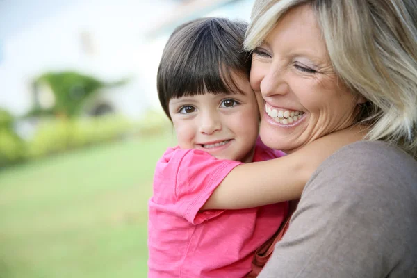 Donna che abbraccia bambina in braccio — Foto Stock