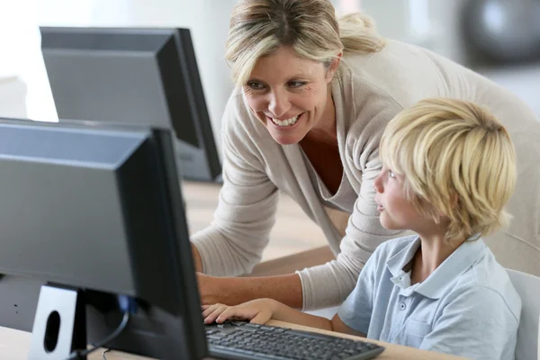 Учитель со школьником учится за компьютером — стоковое фото