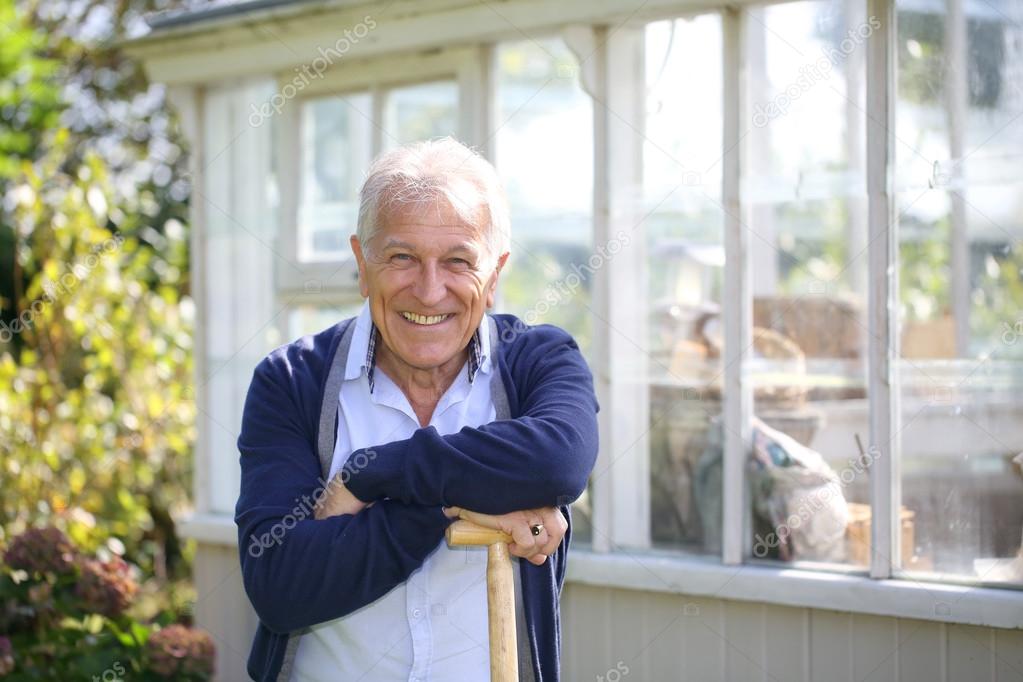 Senior man standing by greenhouse
