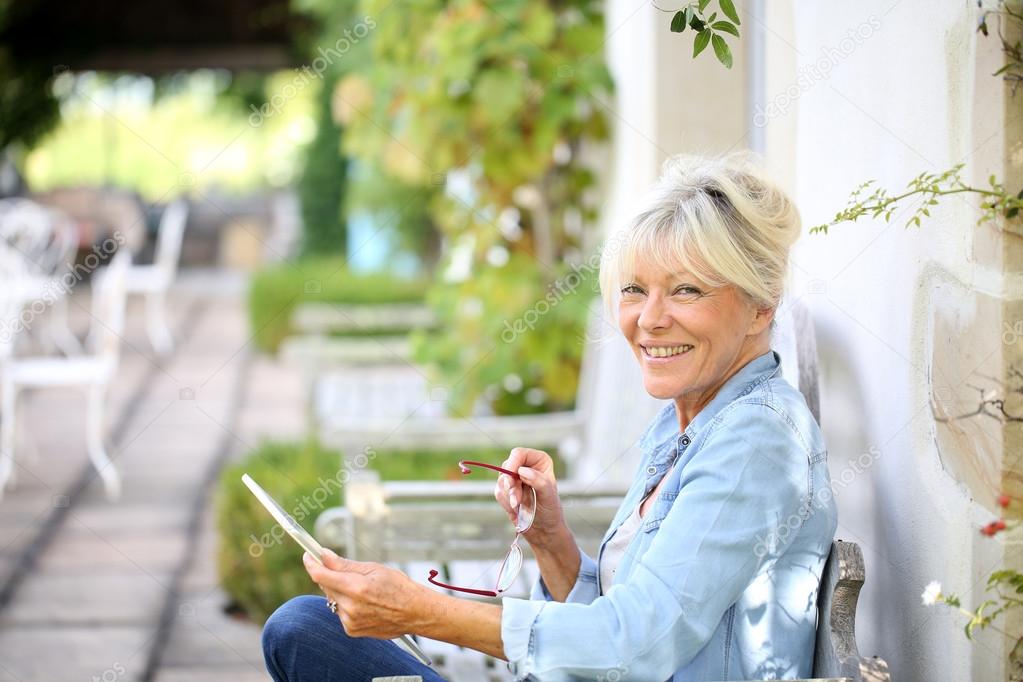 Woman relaxing outside and using tablet