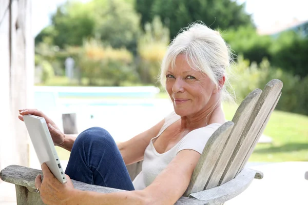 Woman using tablet by swimming-pool — Stock Photo, Image