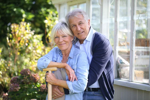 Couple standing by greenhouse in garden — Stock Photo, Image