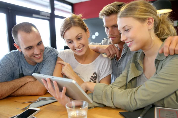 Friends in campus lounge websurfing with tablet — Stock Photo, Image