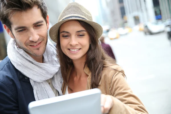 Paar kijken naar toeristische informatie over Tablet PC — Stockfoto