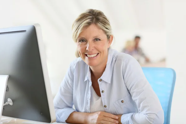 Businesswoman sitting in front of desktop — Stock Photo, Image