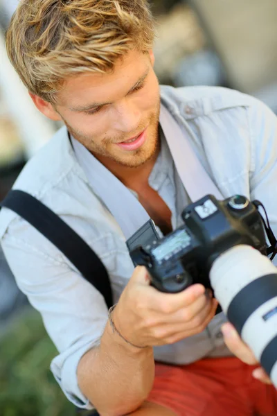 Fotografo con macchina fotografica su panca — Foto Stock