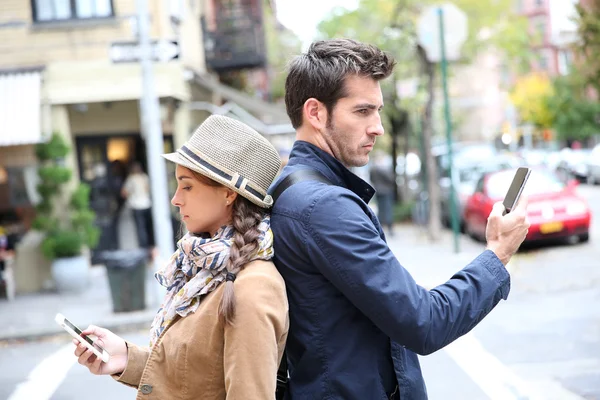 Pareja de pie espalda con espalda en la calle — Foto de Stock