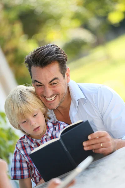 Papai com livro de leitura de criança — Fotografia de Stock