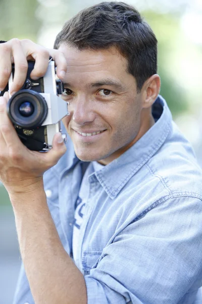 Homem fotografando com câmera vintage — Fotografia de Stock