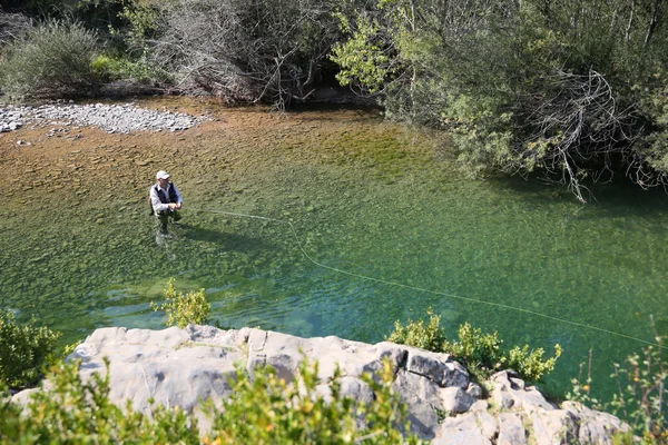 Pêcheur pêche à la mouche dans la rivière — Photo