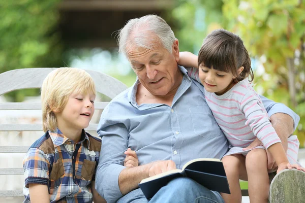 Man reading book with grandkids — Stock Photo, Image