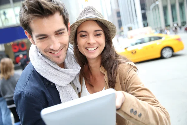 Pareja mirando información turística sobre la tableta — Foto de Stock