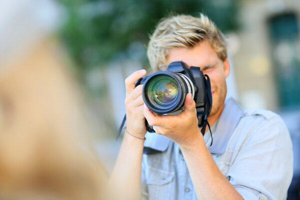 Young photographer shooting model outside