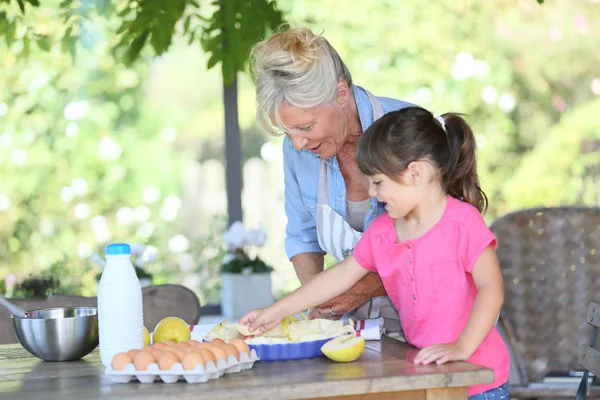 Nenek memasak pie dengan gadis kecil — Stok Foto